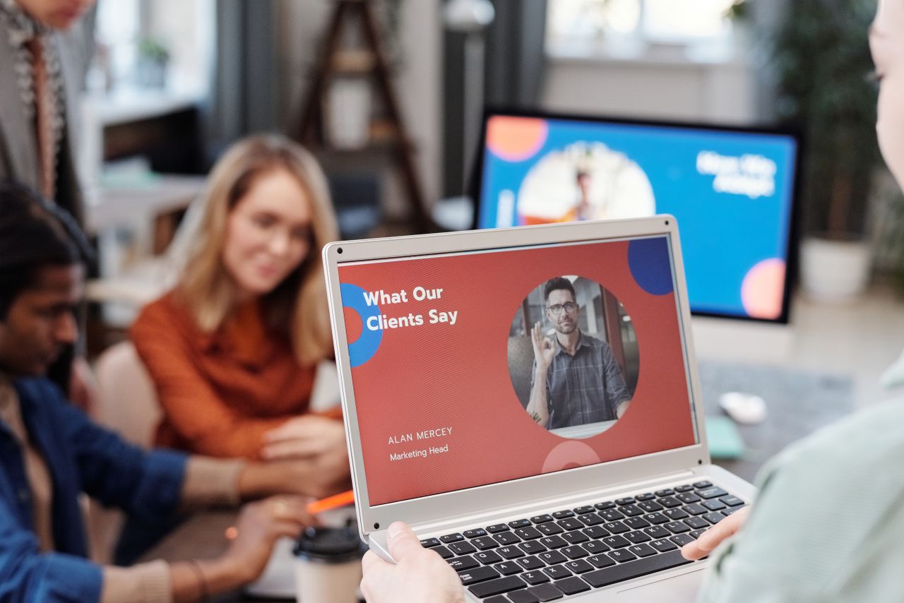 Crafting Captivating Headlines: Your awesome post title goes here Diverse business team in a meeting analyzing client testimonial on laptop screen.