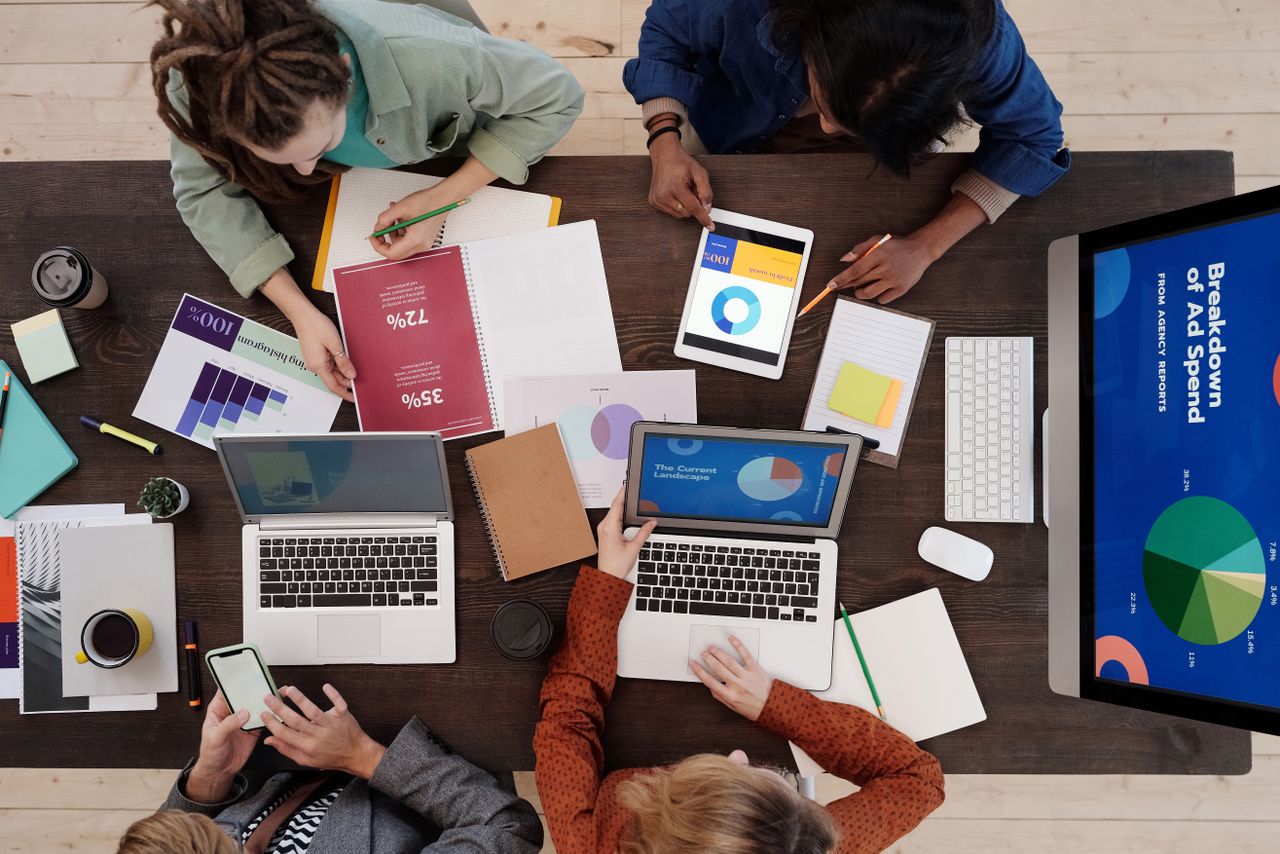 The Art of Drawing Readers In: Your attractive post title goes here A diverse team collaborating on digital marketing strategies at a desk, using laptops and tablets.